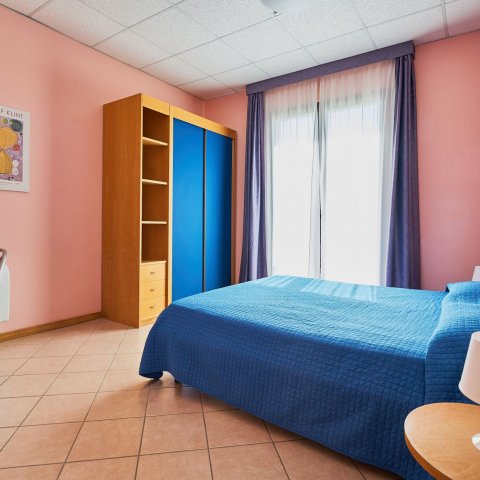 Camera da letto del bilocale per 4 persone con vista mare laterale